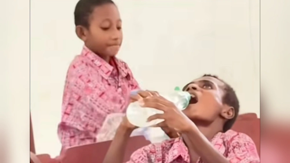 Siswa Papua minum air pakai bekas botol sabun cuci piring. (Instagram)