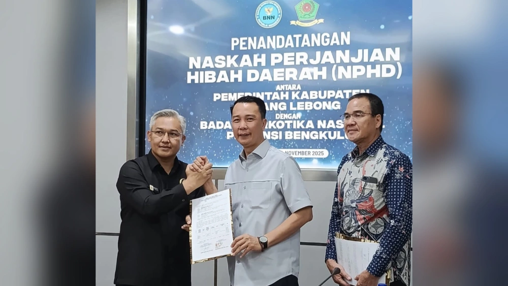 Bupati didampingi Kepala Kesbangpol dan Kepala BNNP Provinsi Bengkulu menunjukkan berita acara NPHD BNNK Rejang Lebong. [MCRL]