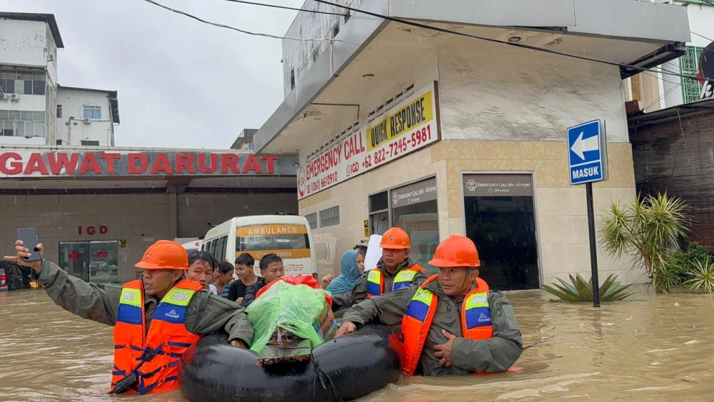 Petugas mengevakuasi korban banjir. [Istimewa]