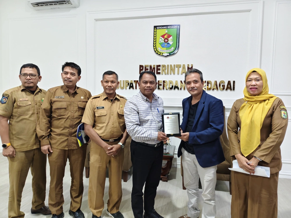Bupati Sergai H Darma Wijaya menerima plakat dari FT News. [Ari FT News]