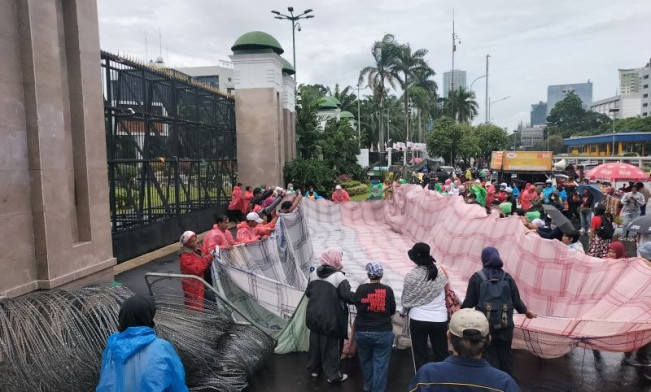 Pekerja Rumah Tangga Bentangkan Serbet Raksasa di Depan DPR RI
