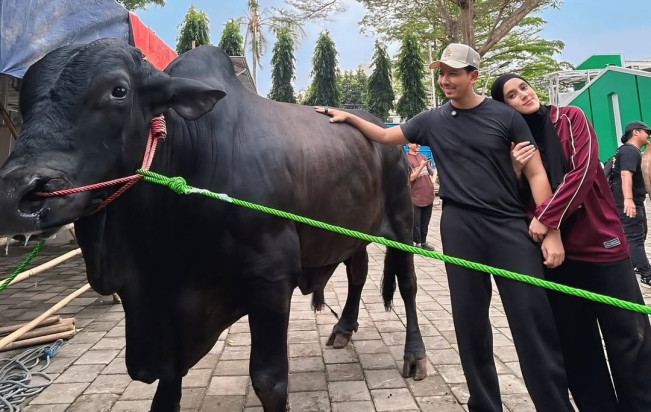 Fairuz A Rafiq dan suami, Sonny Septian, berfoto bersama sapi kurban pemberian Raffi Ahmad. [Instagram @sonnyseptian]
