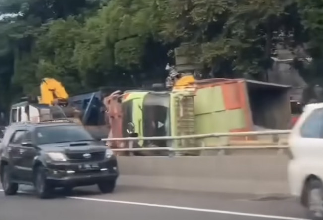 Hantam Separator, Truk Kerikil Terguling Muatan Tumpah ke Jalan