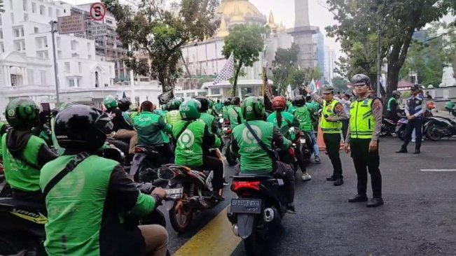 Polisi mengatur lalu lintas dalam aksi demo driver ojol. [FT News/Reza Syahputra]
