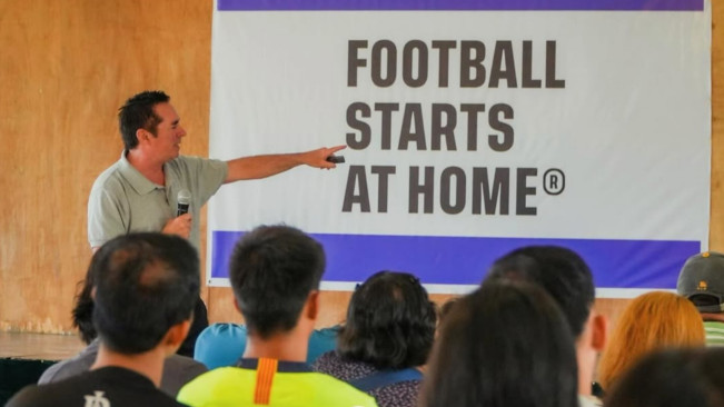 Tom Byer saat menjelaskan bukunya yang berjudul “Football Starts at Home”. [Instagram/@tom.byer]