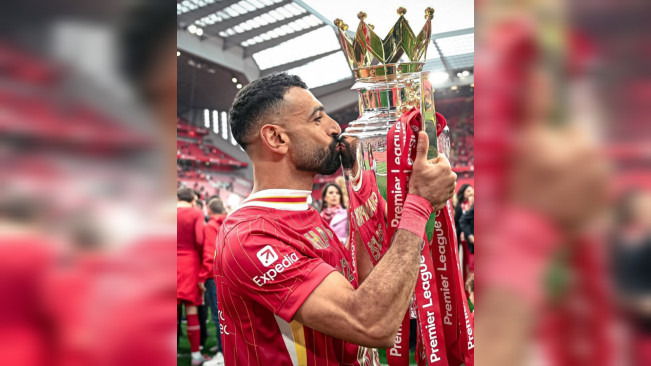 Mohamed Salah mencium trofi Liga Inggris. [Instagram]