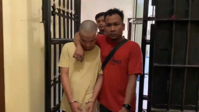 Tersangka Fasiduhu Baene diboyong petugas menuju sel tahanan. [FT News/Reza Syahputra]