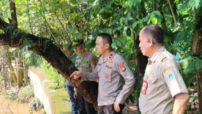 Kapolsek Pancoran Kompol Mansur (kedua dari kanan) dalam kegiatan monitoring dan pengecekan turap di pinggiran Sungai Ciliwung yang longsor akibat luapan air sungai. [Instagram @polsekpancoran]