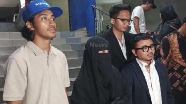 Umi Pipik (tengah) usai melaporkan dua akun medsos yang menghina dirinya di SPKT Polda Metro Jaya, Kamis (22/5/2025) malam. [FTNews.co.id/Selvianus Kopong Basar]  