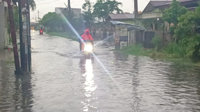 Warga kesulitan melewati genangan air di Deli Serdang. [Dok Istimewa]