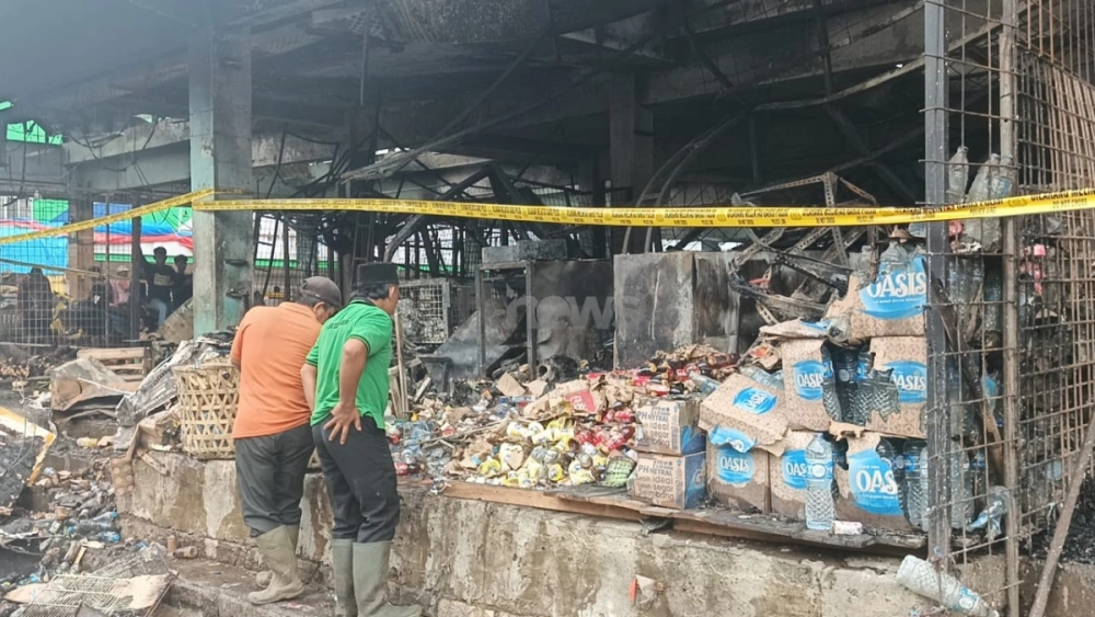 Pedagang korban terdampak kebakaran Pasar Induk Kramat Jati, Jakarta Timur, terlihat tengah memilah dagangannya yang masih bisa diselamatkan, Senin (15/12/2025). [FTNews.co.id/Selvianus Kopong Basar]