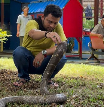 Panji Petualang sedang berinteraksi dengan ular kobra. (Instagram @panjipetualang_real)