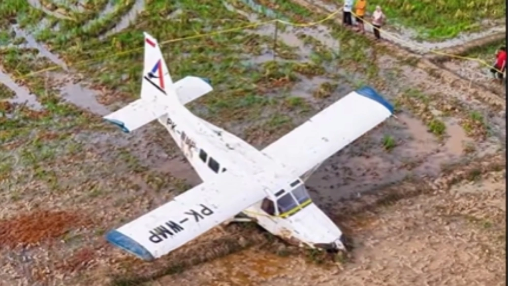 Garis polisi dipasang di sekitar titik jatuhnya pesawat GA28 di areal persawahan Kabupaten Karawang, Jawa Barat. [Instagram]